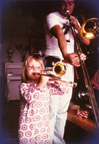 Ellekari, a 4-year-old child, learns how to breathe into a soprano trombone.